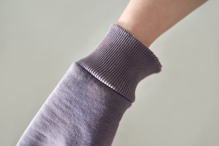 Close-up of adult caucasian female wearing purple sweatshirt with ribbed cuff.の写真素材