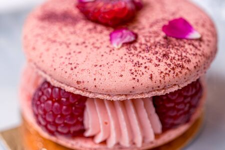 Soft focus background. Pink Raspberry Macaron cookies on blue plate. Tea time. Blue table background. Top view.の写真素材