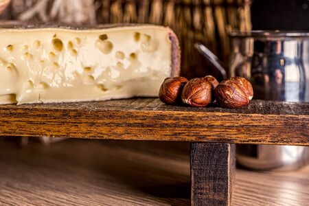 French cheese Saint Nectaire rustic collection delicious. Black background.