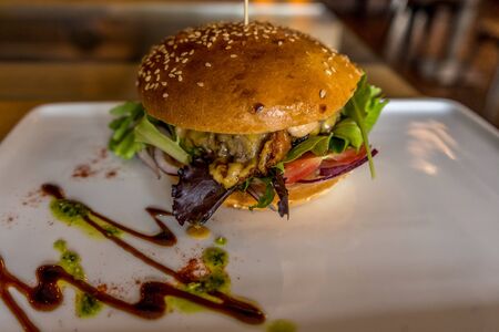 Hamburger in the white plate on a table. Rustic closeup.の写真素材