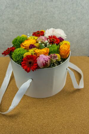 Flower bouquet in the white box on the natural wood background. Spring style. Romantic wedding background. Floral design.の写真素材