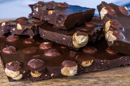 Pieces of black chocolate. Wooden texture background. Sweet food. Food set. High quality photoの写真素材