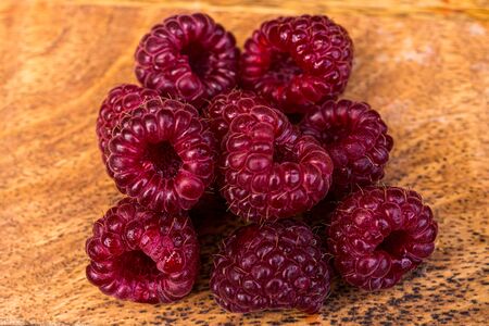 Juicy raspberry close up macro on a wood background. Nature background. Fresh fruit. High quality photoの写真素材