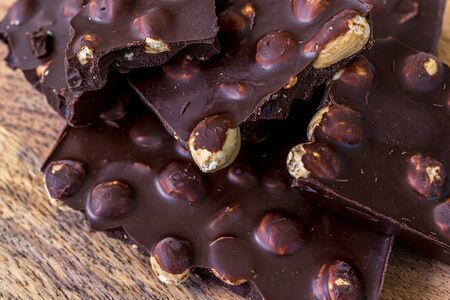Pieces of black chocolate. Wooden texture background. Sweet food. Food set. High quality photo