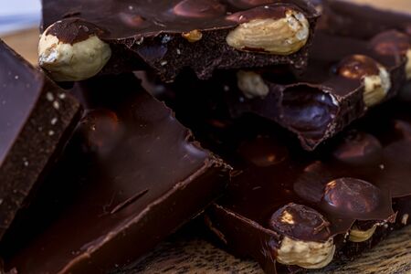 Pieces of black chocolate. Wooden texture background. Sweet food. Food set. High quality photoの写真素材