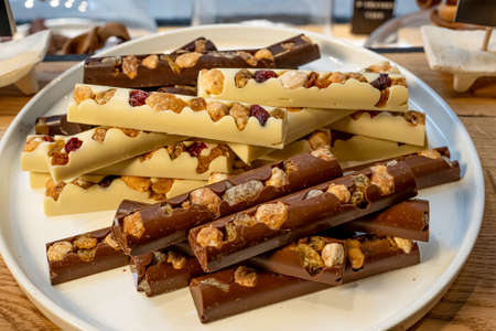 Three types of chocolate with dried fruits on the white background. Macro close of french chocolate....