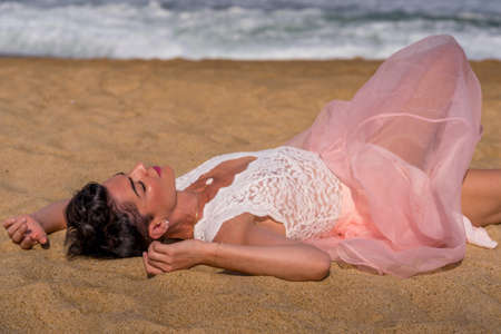 Sexy woman laying on the beach. Beautiful model. Soft background. High quality photoの写真素材