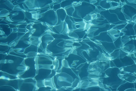 Swimming pool water texture in abstract style on blue background. Vacation, holiday. Ripple water. Watercolour abstract texture. Swimming pool water sun reflection background. Summer vacation.の写真素材