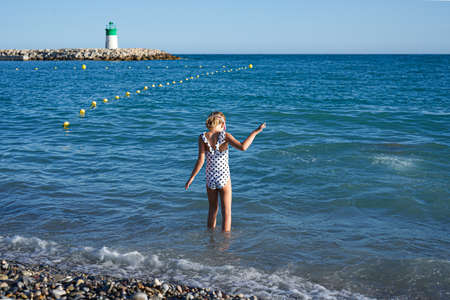Little girl goes swimming in the mediterranean sea. High quality photoの写真素材