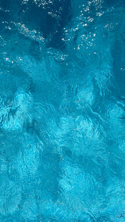 Soft focus background. Swimming pool water texture in abstract style on blue background. Ripple...