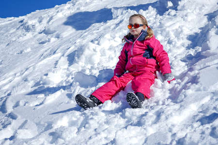 Young Girl Sitting On The Snow Mountain. Winter timeの写真素材