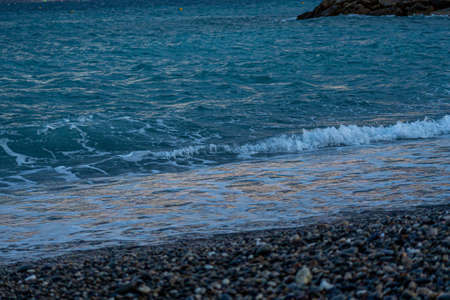 Evening on a coast. Abstract blue closeup on transparent background. Beach vacation. Water splash. Foam water. Liquid texture background. High quality photoの写真素材
