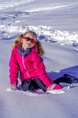 Soft focus background. Outdoor winter portrait of little cute girl wearing ski clothes. Stylish clothes for kids.の写真素材