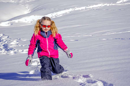 Soft focus background. Young Girl With Sunglasses Playing In The Snow. Winter sunny day on the french alpsの写真素材