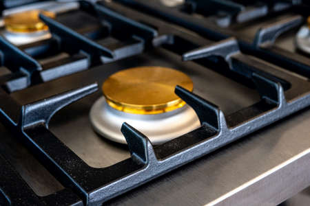 Gas stove with and embedded electric oven at brand new modern wooden kitchen. Close up photoの写真素材