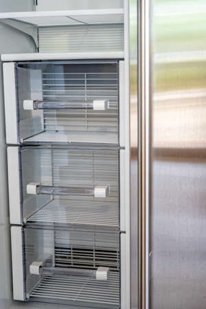 Open empty white refrigerator. Side View of Stainless Steel Double Door Refrigerator. Modern Kitchen and Domestic Household Appliances.の写真素材