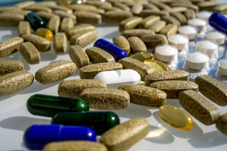 Close-up of different pills and capsules are on the table from virus. Selective focus. Assorted pharmaceutical medicine pills, tablets and capsules.の写真素材