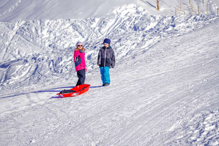 Two joyful kids sledding down the hills on a winter day. Brother and sisterの写真素材