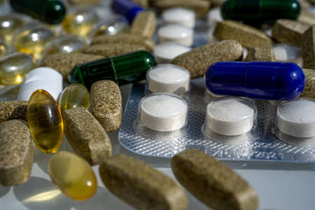 Close-up of different pills and capsules are on the table from virus. Selective focus. Assorted pharmaceutical medicine pills, tablets and capsules.の写真素材