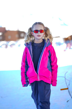 Soft focus background. Young girl descends from the snow mountain in winter clothes. Snow background.の写真素材