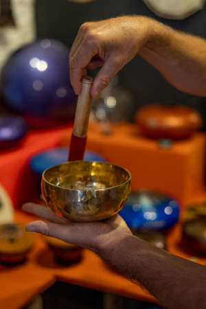 Man playing on tibetian singing bowl. Relaxation, meditative and traditional music concept. Close up shot. Soft focus backgroundの写真素材