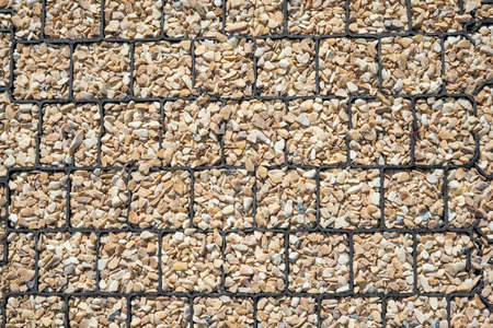 Cover gravel stones design on beige backdrop. Surface design. Background texture garden paths....