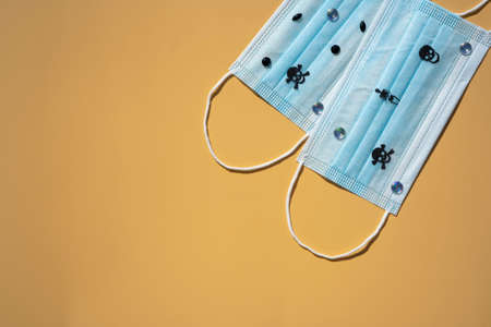 Protective surgical masks with skulls and rhinestones. Hallowing concept. Isolated on beige...