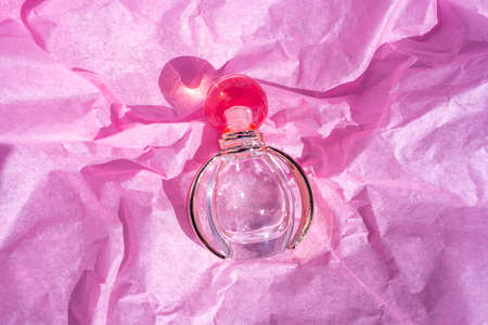 Bottle of Perfume - Fragrance bottle in pink and gold on the rose color paper background. Close-upの写真素材