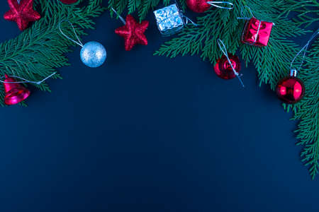 Christmas composition. Fir tree, silver and red decorations on black background. Flat lay, top view, copy space.の写真素材