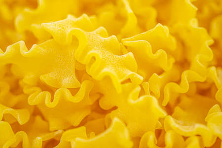 Italian dry wavy pasta background. Healthy traditional food. Top view. Macro close-up. High quality photoの写真素材