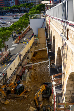 Monte-Carlo, Monaco 29.11.2020 Two caterpillar excavators working on construction site in the day. Construction machinery for excavation, loading, lifting and hauling of cargo on job sitesのeditorial素材