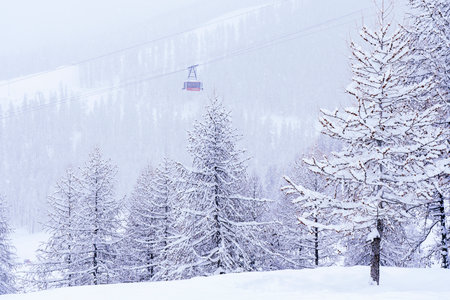 Landscape from top of mountain resort in french Alps with ski slopes and cable car transporting. Snow-covered forest, photographed from above. High quality photoの写真素材