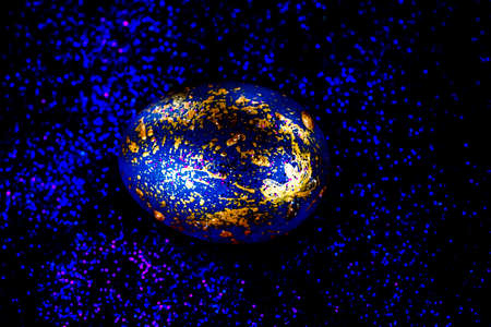 Abstract photo of eggs on galaxy glitter dark background. Easter cosmic space colored eggs. Idea for...