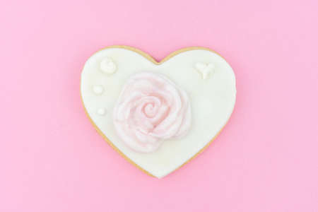 Decorated heart shaped organic cookie with beautiful rose on color background, top view. Valentines day treatの写真素材
