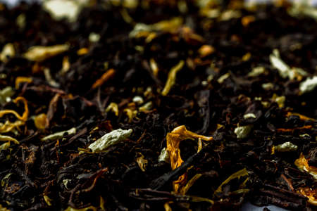 Delicious Black tea flavored with safflowers petals and bergamot pronounced taste. Selected focus Macro close up photography of tea leaves background. Sharp and vivid colors, ideal for advertising.の写真素材