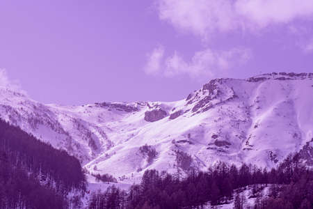 Winter landscape of mountains and sunny day with special magenta color filter. French alpines. Free space for your decoration.の写真素材