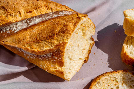Delicious fresh baked baguette cut on a wooden cutting board.の写真素材