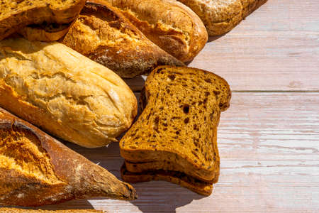Different kinds of fresh bread on wooden surface. Close up. Bakery concept.