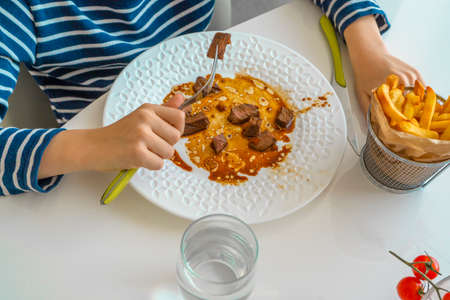 Boy eating Duck breast fillet served on a white plate, fried with garlic, special asiatic soy sauce recipe.の写真素材