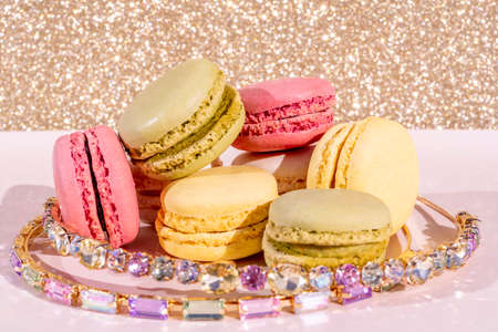 Pink, yellow and green macarons on light wooden background. French Pastel Macaroons. Blurred focus. High quality photoの写真素材