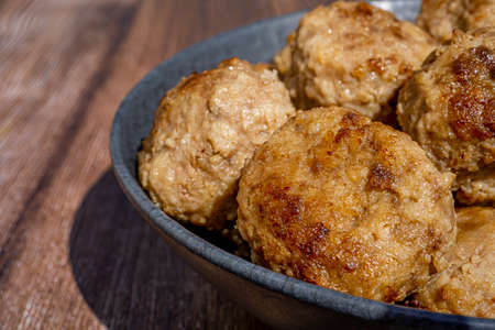 Minced meat ball in black plate, selective focus. Homemade cutlets on a wooden background in rustic style with copy space. Top view, flat lay, close upの写真素材