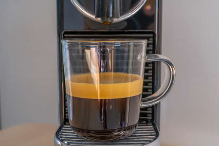 Making strong coffee with espresso machine at home. Front view.