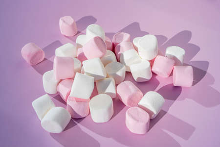 Colorful mini marshmallows on pink background. Flat lay, top view. Children holidays food concept.