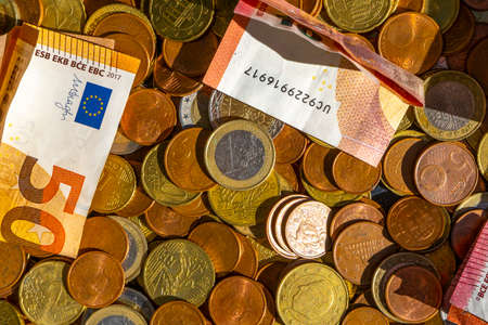 Euro banknotes and coins of European currency as background. Handful of coins. Scattering of coins. Euro cent coins. Hight quality photoの写真素材