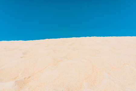 Scenic landscape of yellow sand dunes and blue sky background. High quality photo