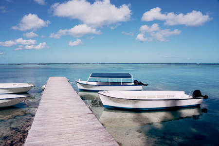 Wooden motorboat bridge with boats on the tropical island. Beautiful paradise island background....
