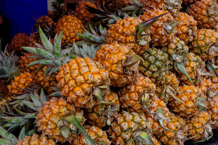 Mauritius, Island - 30.10.2021: Ripe pineapple Victoria for sale at a market in Mauritius. Pineapple texture background. High quality photoの写真素材