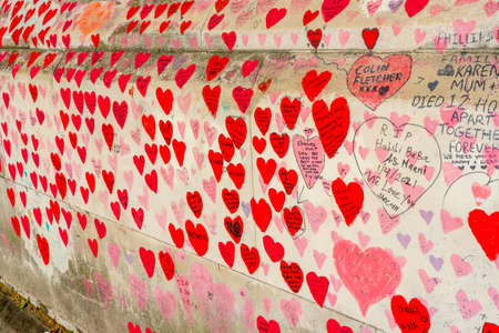 Westminster, London UK - 20.04.2022: The National COVID Memorial Wall painted with red hearts with...