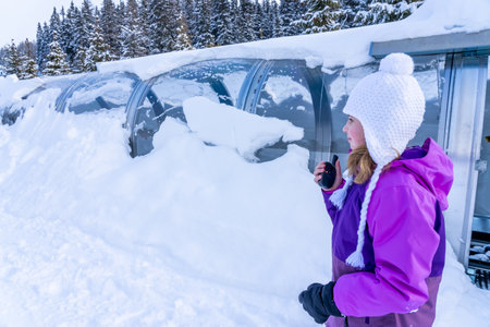 A girl standing near magicagic carpet ski lift in a glass tunel. Snowy winter day in the french ski...