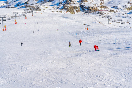 Alpe D'Huez, France - 31.12.2021: Skiers skiing, chairlifts in Alpine ski resort on bright winter day. Winter holiday, family recreation in snow mountains. High quality photoのeditorial素材